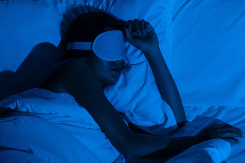 Woman sleeping with a sleep mask on her eyes in the bedroom