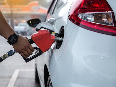 Closeup of woman pumping gasoline fuel in car at gas station. Petrol or gasoline being pumped into a...