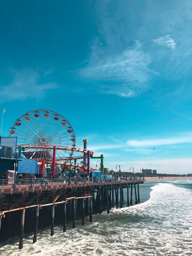 The Santa Monica Pier in California features a carousel, Ferris wheel, and lots of colorful rides on...