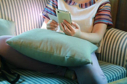women sitting on green sofa and hand play phone, Internet of things lifestyle with wireless communi...