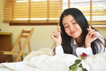 Young beauty women with rose flower is on bedroom