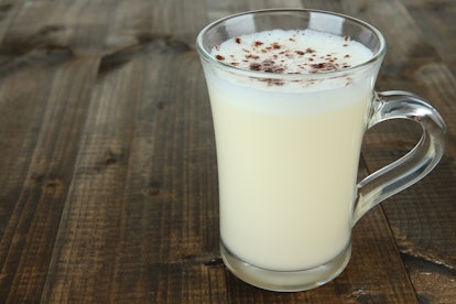 Cup of eggnog on wooden background