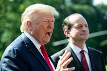 US President Donald Trump (L) delivers remarks to members of the news media beside US Labor Secretar...