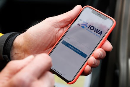 Precinct captain Carl Voss, of Des Moines, Iowa, holds his iPhone that shows the Iowa Democratic Par...