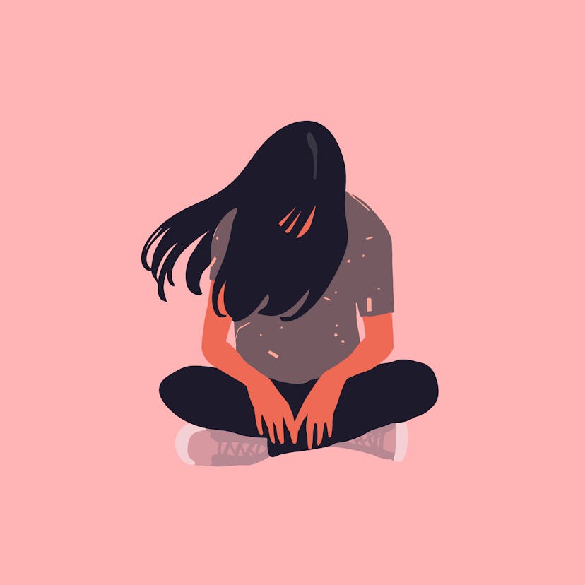 Sad and lonely teenager girl sitting in lotus position on the floor and lowered her head down. Depre...