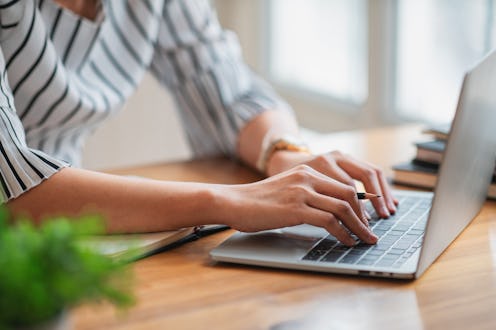 Hands typing on laptop keyboard