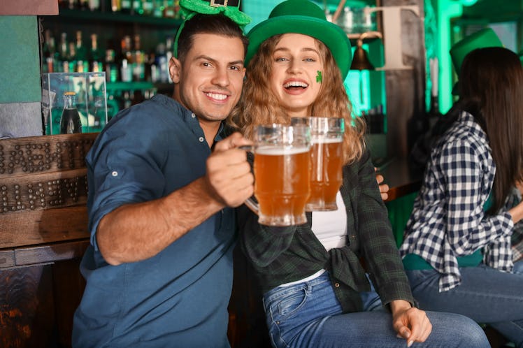 A couple clinks their beers while celebrating St. Patrick's Day.