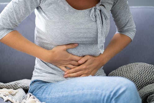 Portrait Of Woman With Stomach Ache Sitting Sofa