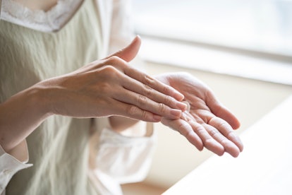 Hands of woman applying hand cream