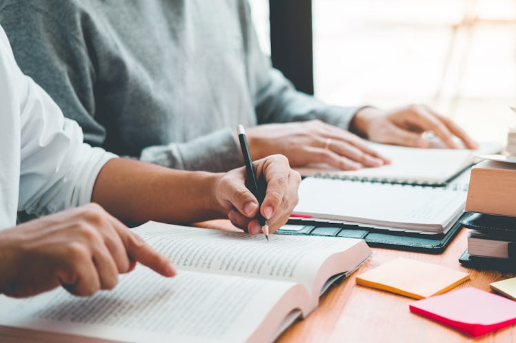 University students or college students studying and reading together in library.