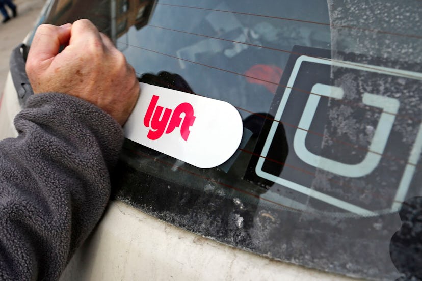 This is a Lyft logo being installed on a Lyft driver's car who also drives for Uber on in Pittsburgh
