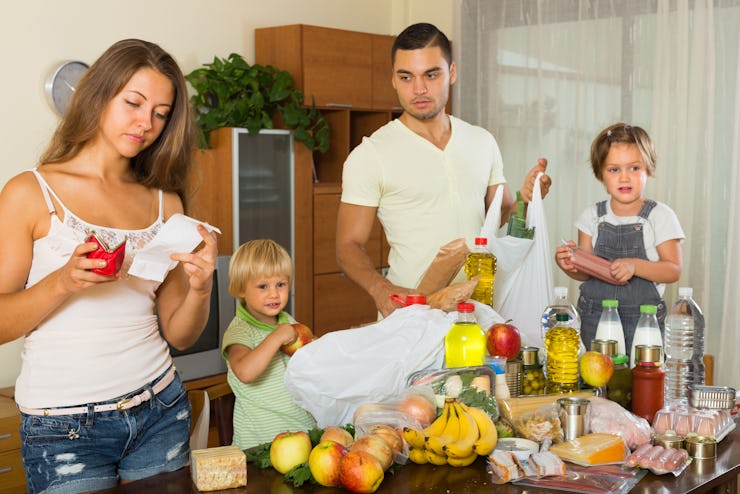 Sad woman with receipt from store, family brought food home. Focus on woman
