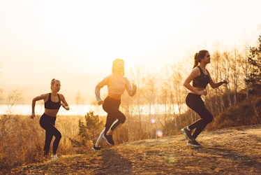 A group of girls jogging, climbing the mountain in the morning sun.
