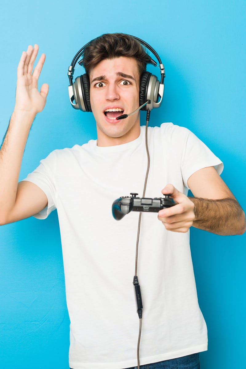 Teenager caucasian man using headphones and game controller
