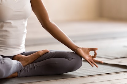 Yogi black woman practicing yoga lesson, breathing, meditating, doing Ardha Padmasana exercise, Half...