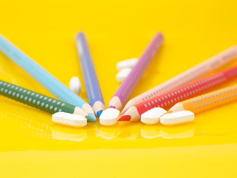 Medication for children concept. Color pencils and drugs on yellow background