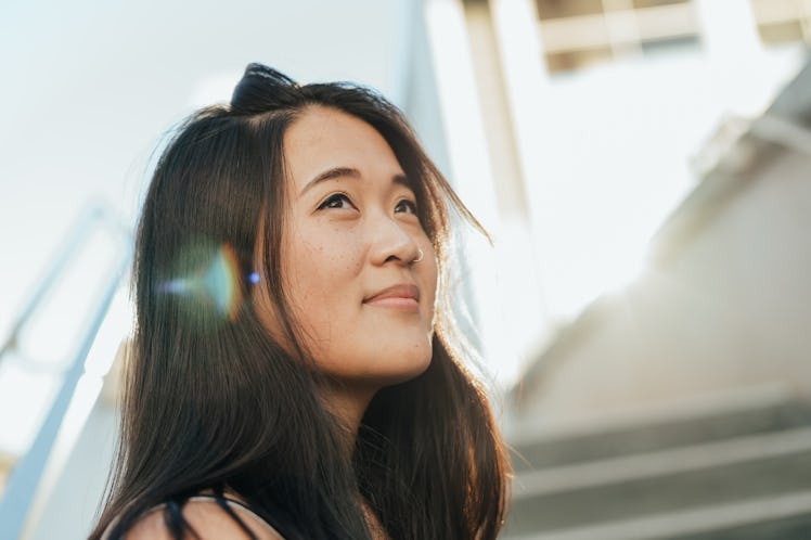 dreamy asian woman looking towards sky