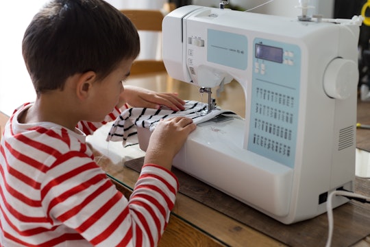 a boy sews on a sewing machine
