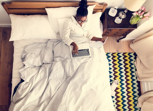 African American business woman on bed working
