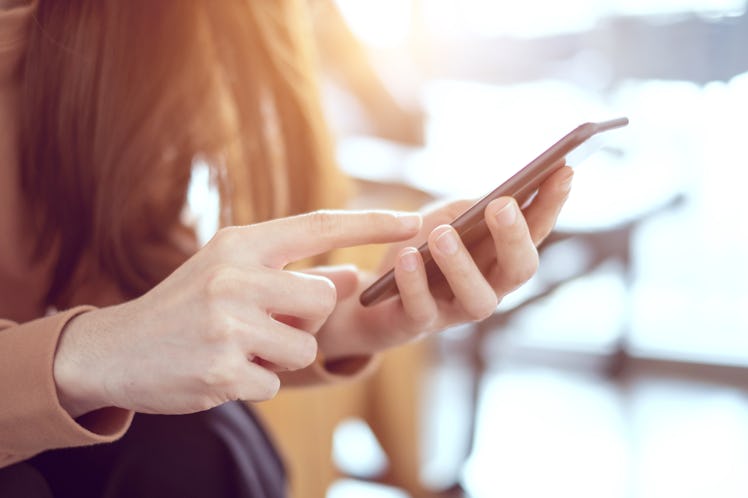 Close up woman hand holding smartphone, She using in mobile applications and multimedia programs. co...