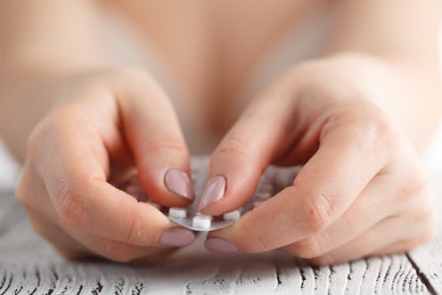 Contraceptive Pill in female hands ready to eat