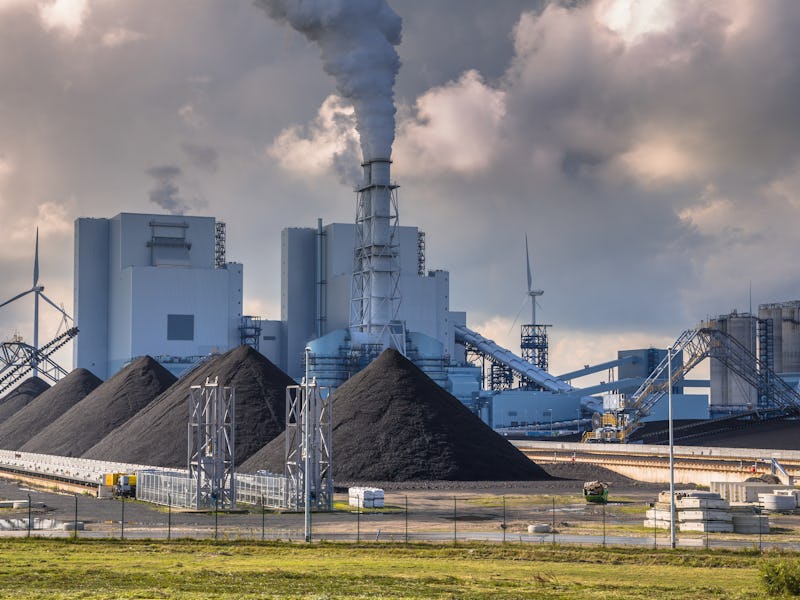 Heavy industrial coal powered electricity plant with pipes and smoke in black and white