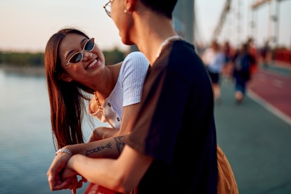 Love and date concept. Young happy stylish asian woman in cat eye sunglasses looking to her beloved ...