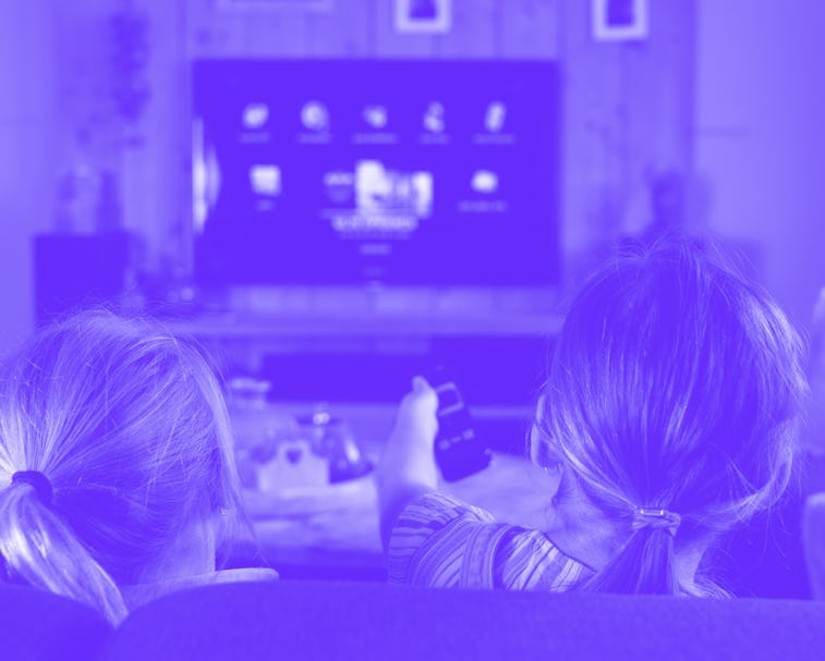 two children sliding through the apps on a smart tv. back of the children with the focus on the chil...