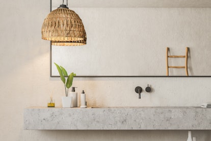 Close up of marble bathroom sink standing in room with white walls and big horizontal mirror hanging...
