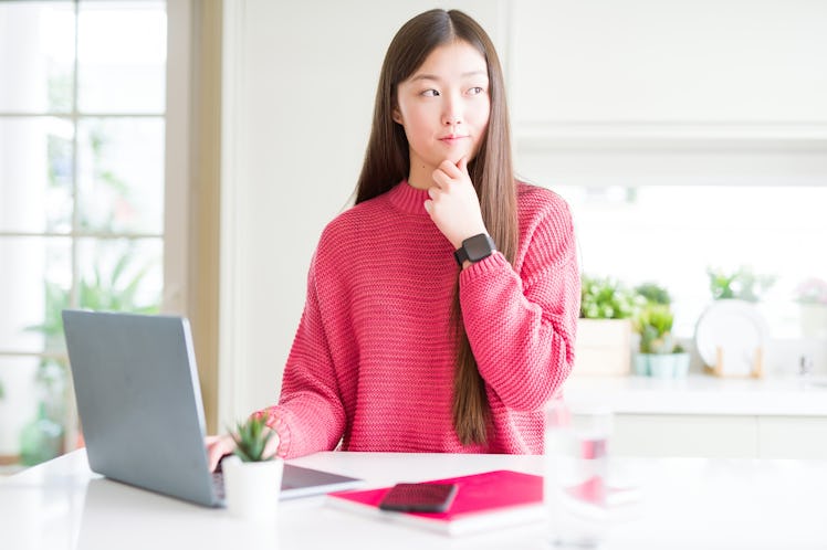 Beautiful Asian woman working using computer laptop serious face thinking about question, very confu...