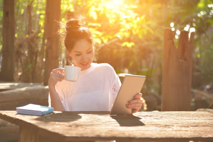 Women with mobile phones and tablets in the beautiful backyard.