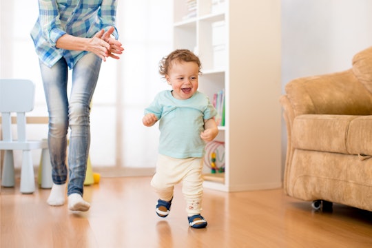 Baby toddler have a fun running in living room with his mother