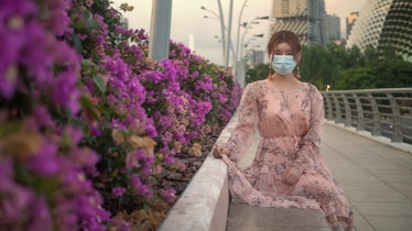 Asian Chinese girl wearing a surgical face mask to protect herself from COVID-19 coronavirus infecti...