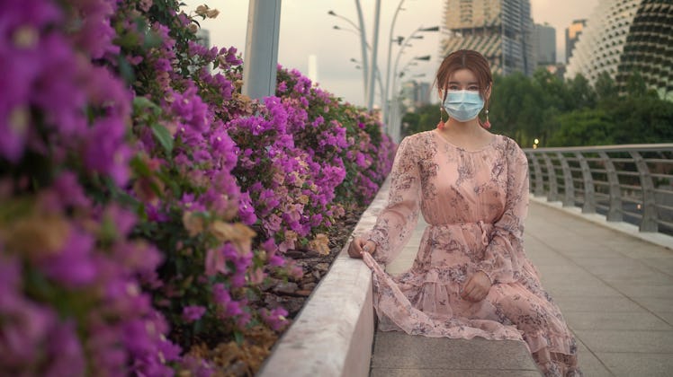 Asian Chinese girl wearing a surgical face mask to protect herself from COVID-19 coronavirus infecti...
