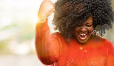 Beautiful african woman happy and excited expressing winning gesture. Successful and celebrating vic...