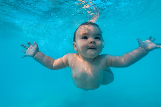 Beautiful Baby infant in sea tropical water underwater shot