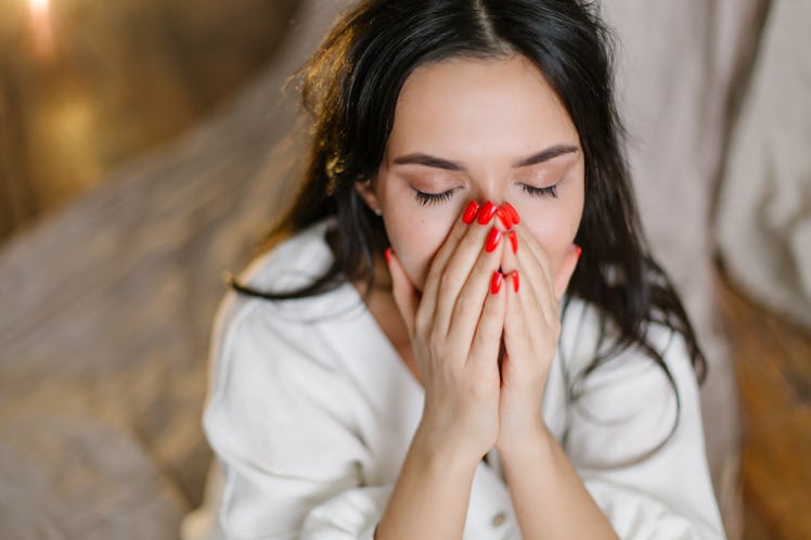 A beautiful oriental girl crying closes her eyes with her hand in a depressed state. Diagnosis psych...