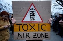 A Romanian environment activist young woman waves a placard during a protest, named 'Clean air, not ...
