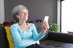 Grandmother looking at phone, laughing at april fools' day prank