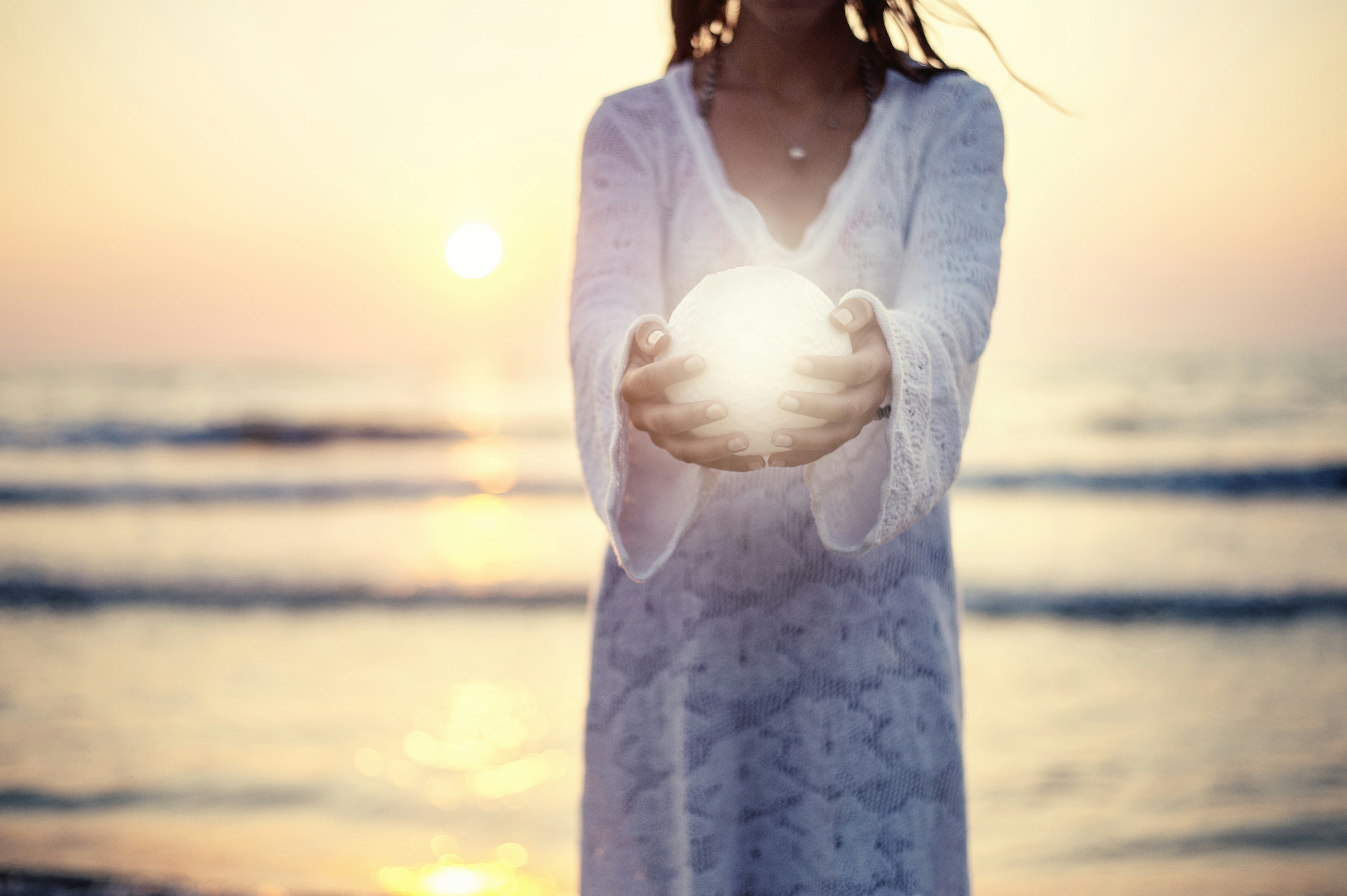 Close up moon in woman's hands sunset on the beach seaside background
