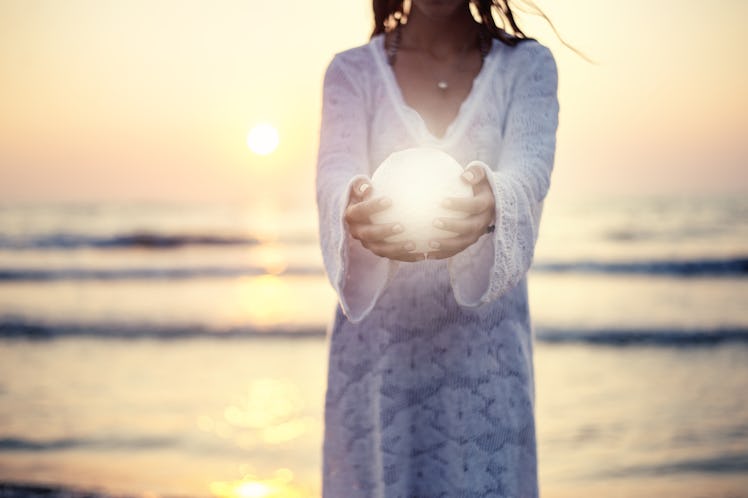 Close up moon in woman's hands sunset on the beach seaside background