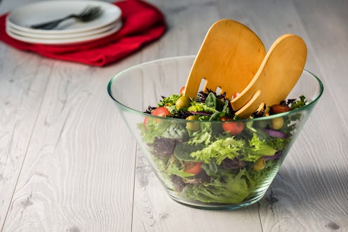 Green salad in glass bowl on a grey rustic table
