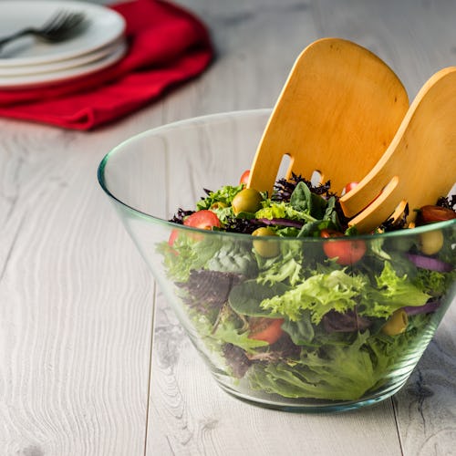 Green salad in glass bowl on a grey rustic table
