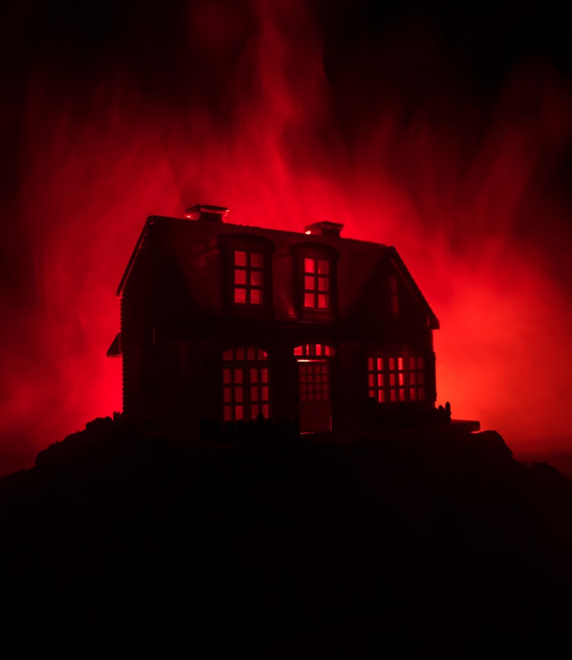 Old house with a Ghost in the forest at night or Abandoned Haunted Horror House in fog. Old mystic b...