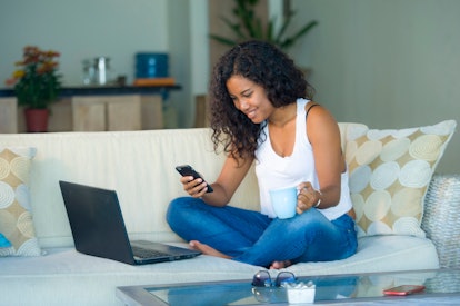 lifestyle portrait of young happy and beautiful black afro American woman using internet texting on ...