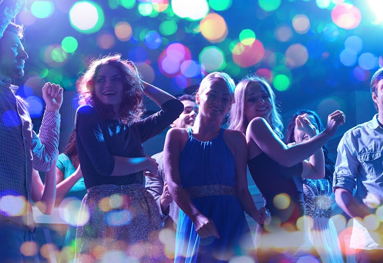 party, holidays, celebration, nightlife and people concept - group of happy friends dancing in night...