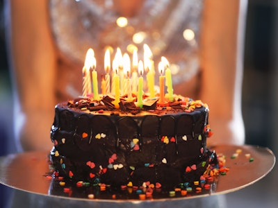 Young woman with birthday cake, closeup