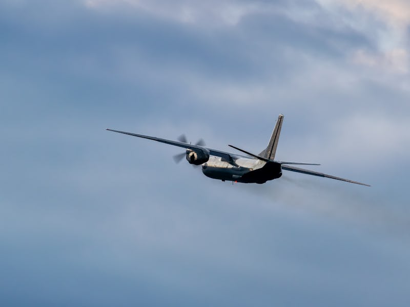 Turboprop cargo plane is rolling after takeoff on stormy sunset