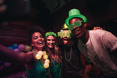 A group of friends who smile for a selfie and celebrate St. Patrick's Day at a bar will need St. Pat...