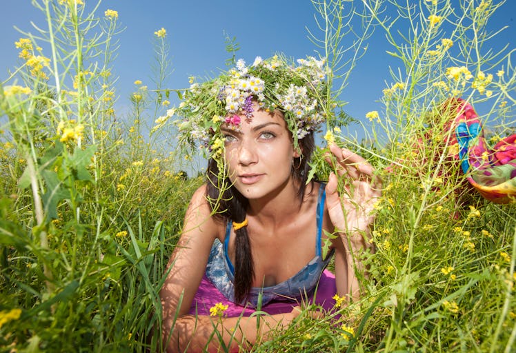 girl in a flower wreath lies in the grass